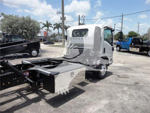 Isuzu NRR cab chassis with a hook lift mounting and chassis spine visible; truck in a dealership lot