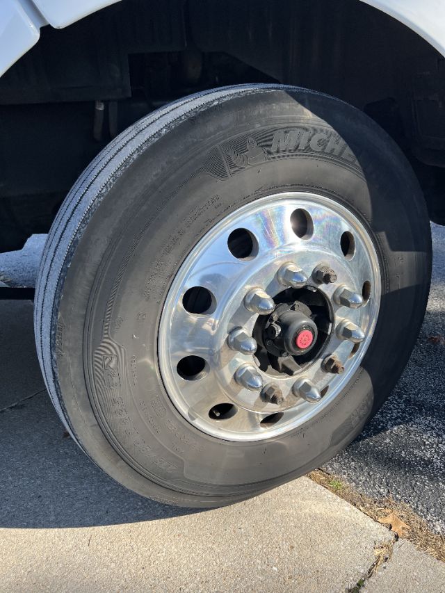 Wheel and tire of a Peterbilt truck indicating a chrome hub with lug nuts and Michelin tire on front axle