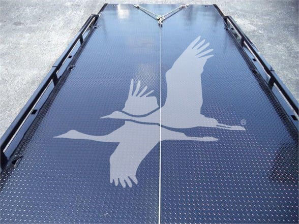 Trailer deck with diamond plate surface and white stenciled birds logo. Visible text/labels: none readable beyond generic deck texture.