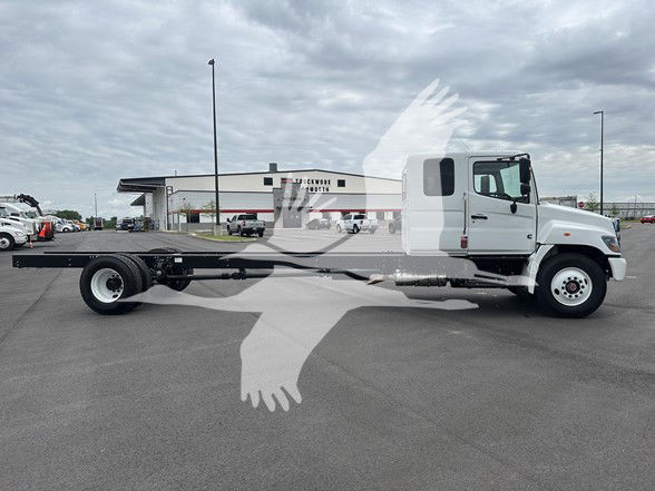 2026 Hino L6 cab and chassis truck side view with elongated chassis frame and single rear axle, white cab, dealership lot background.