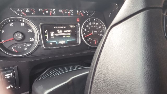 Interior dash of a 2019 International conventional truck showing gauges and a central display reading fuel economy and other metrics.