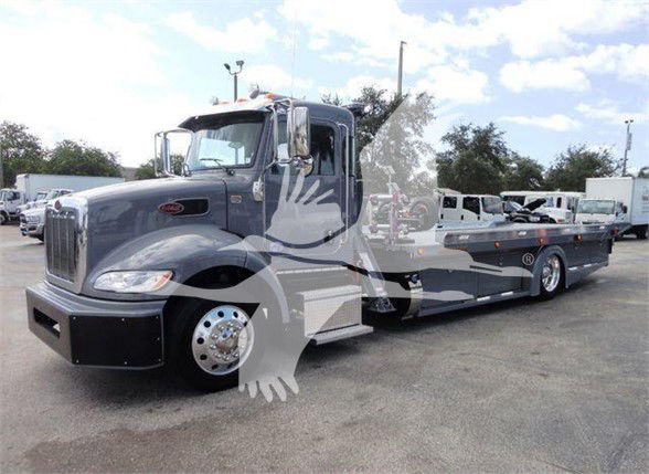 2022 Peterbilt 337 tow truck tractor in a parking lot with long wheelbase and flatbed; VIN 2NP2HM6X9NM804653 and stock number J04653 visible.