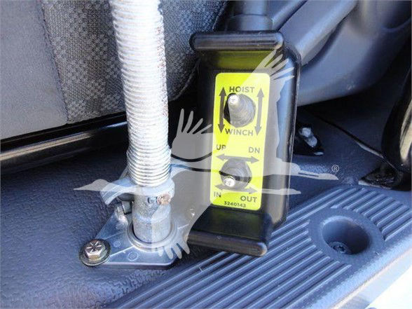 Isuzu NRR truck bed area showing a hydraulic hoist control with yellow label and hydraulic line fittings.