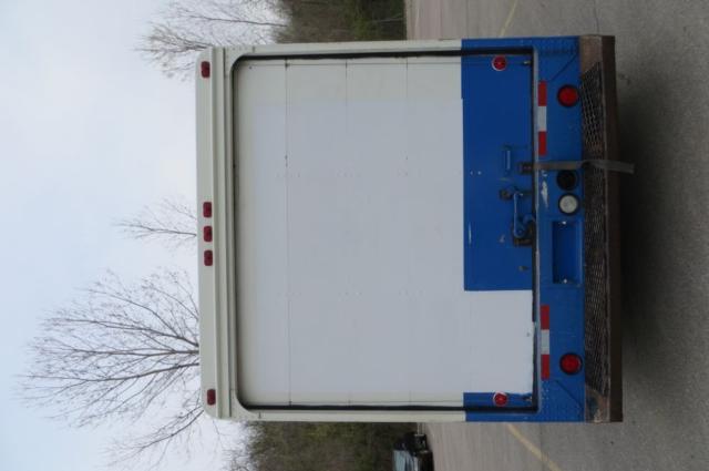 Back of a 2000 Freightliner MT35 box truck showing a white cargo door and blue frame with red and white taillights.
