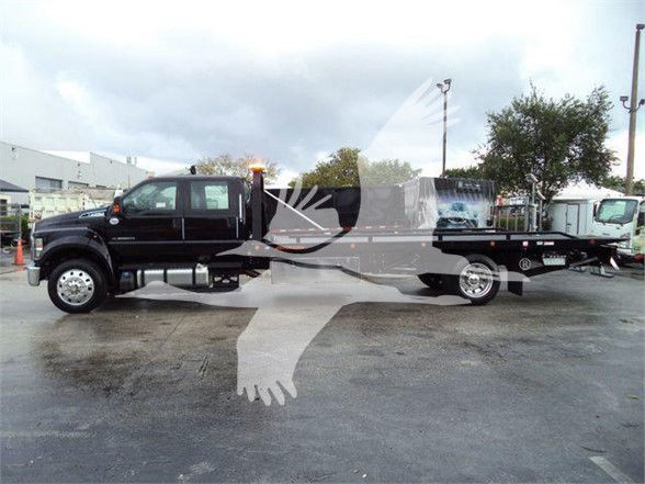 Ford F-750 SD tow truck side view showing extended flatbed and dual rear wheels.