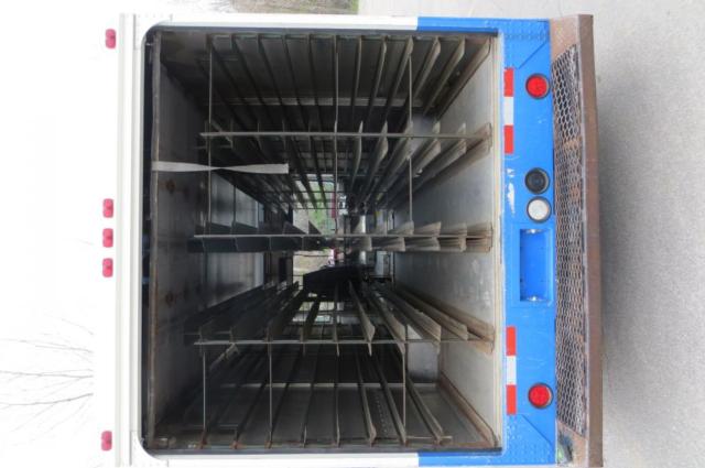 Empty Freightliner MT35 step van cargo area with vertical load bars and tie rails visible, interior metal walls and floor.