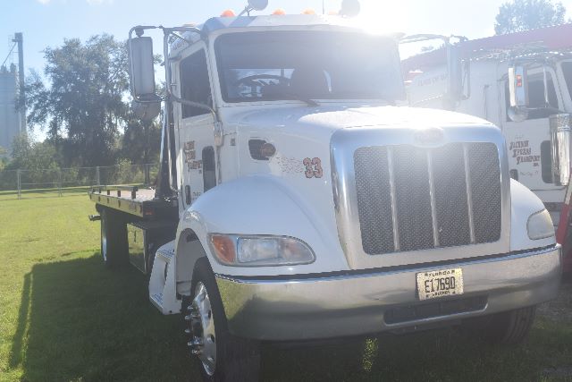 Peterbilt 337 rollback truck front view showing large chrome grille and white cab with florida tag; used vehicle.