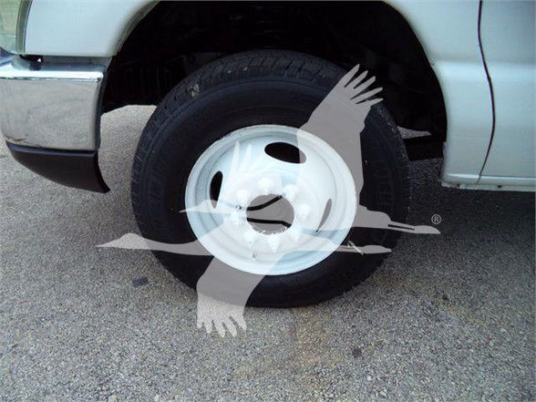 Flatbed truck wheel and front fender of a 2011 Ford E450 with white steel wheel. No visible text other than watermark graphic.