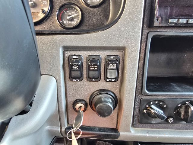 Dashboard area showing cruise control and ignition key with a blank cup holder and gauges.