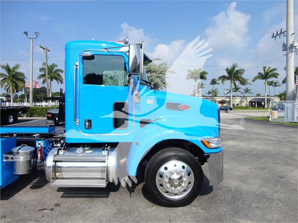 2002 Peterbilt 337 cab truck side profile in blue, with chrome fuel tanks and wheel, no visible text on side except small emblem near front fender.