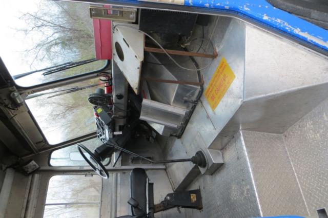 Freightliner MT35 step van interior showing driver seat, steering wheel, gear selector, and metal floor with diamond plate.