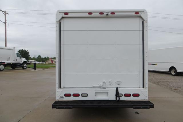 Freightliner MT45 rear view showing roll-up cargo door and bumper, with taillights and a black step plate.