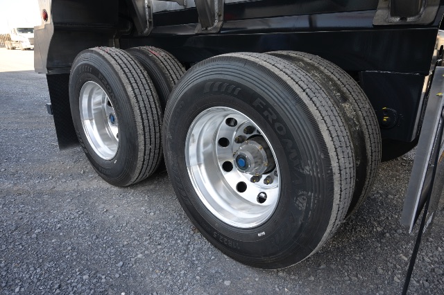 Trailer wheels and aluminum frame showing dual rear axles on a new TruxTon 150BBL aluminum vacuum trailer.