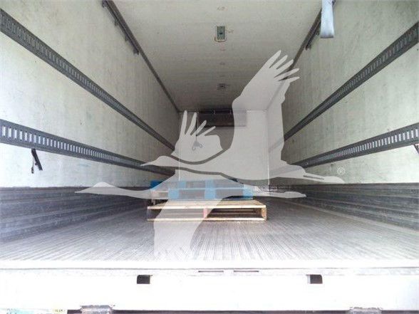 Trailer cargo area showing empty reefer truck interior with pallet on wooden pallet at center.
