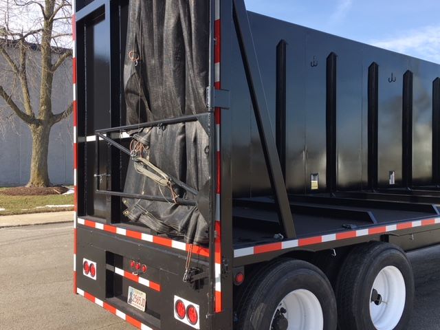 Great Dane SINGLE DROP crusher car carrier trailer showing rear entry with tarp and swing-out latch, red/white safety reflectors, dual rear lights, and white wheels.