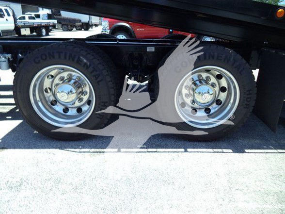 Truck rear wheels with Continental tires and dual axles visible under a Kenworth T880 trailer.
