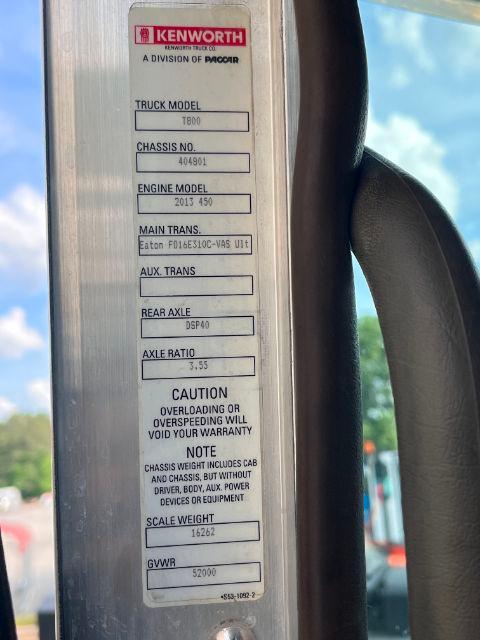 Vertical metal placard on Kenworth T800 door jamb listing truck model, chassis number, engine model, transmission, axle ratio, and GVWR.