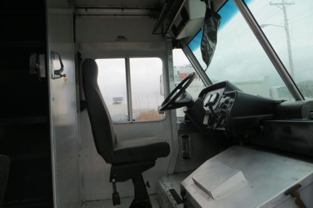 Truck cab interior showing steering wheel and driver's seat in a Freightliner MT45 step van.