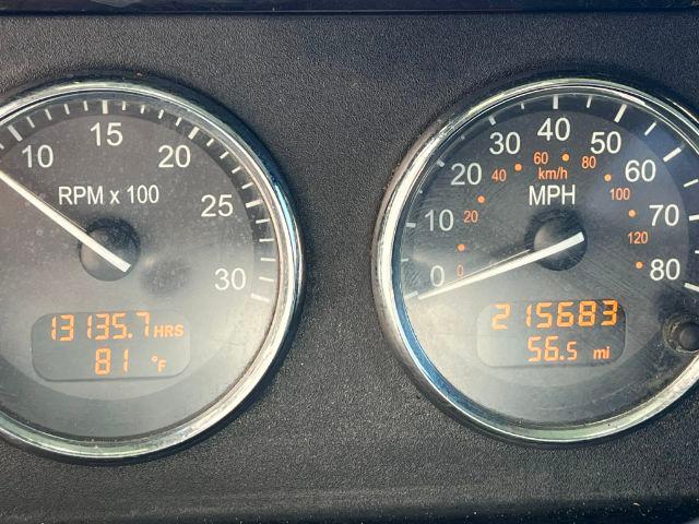 Dashboard gauges showing tachometer (RPM x100) and speedometer (MPH/kmh). Digital displays show 13135.7 hours, 81°F on left; odometer 215683 miles and 56.5 mi on right.