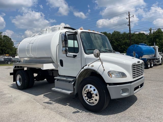 White 2013 Freightliner M2 sewer service truck with a cylindrical vacuum/tank on the back, front cab, and side steps.