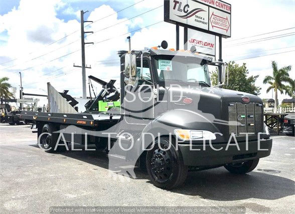 Peterbilt 337 tow truck front view with extended cab and flatbed, stock number J99287, appears new.