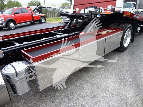 Peterbilt 337 stake bed truck chassis showing polished aluminum toolboxes and frame.