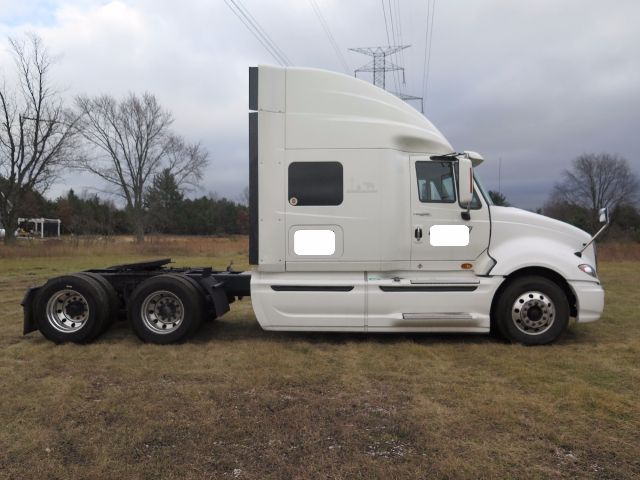 International ProStar truck cab and chassis side view with sleeper, white exterior.