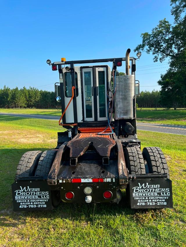 Truck cab of a 2015 Tico Prospotter viewed from rear with dual rear wheels and Web Brothers Services mudflaps.