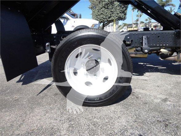 Isuzu NPR HD truck chassis showing front wheel and frame with white steel rim.