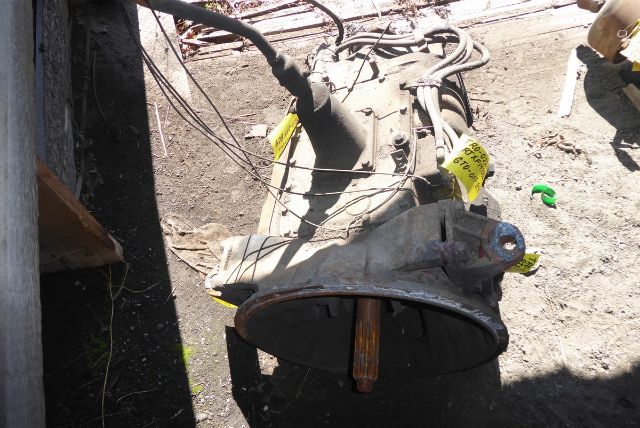 Transmission component with input shaft visible, labels attached, and wiring harnesses extending from the top.