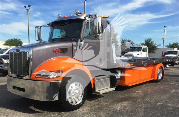 Peterbilt 337 tow truck in gray and orange colors, front angled view with flatbed, chrome bumper, and large side mirrors.