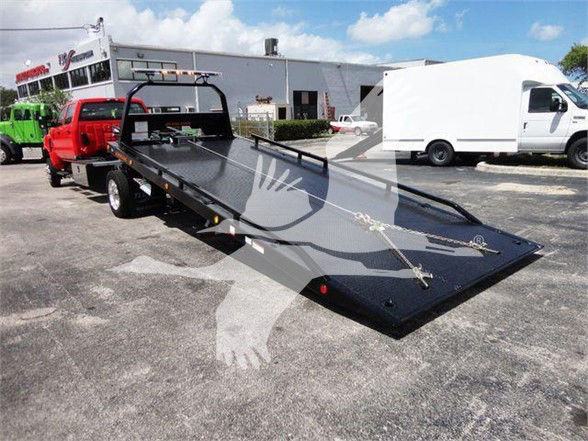 Flatbed tow truck bed extended on a 2023 International CV with diagonal ramp and front-mounted guard rails