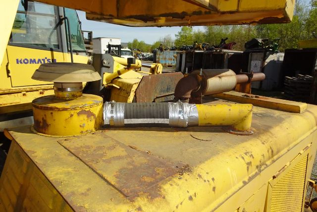 Tractor crane top of a yellow Grove RT58 truck-mounted crane showing hydraulic hoses and cap.