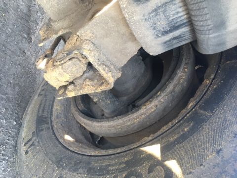 Trailers showing wheel hub and suspension: inner coil spring and circular hub area with dirt and rubber wheel.