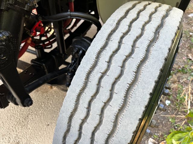 Truck wheel and tire with visible tread pattern and suspension components in view.