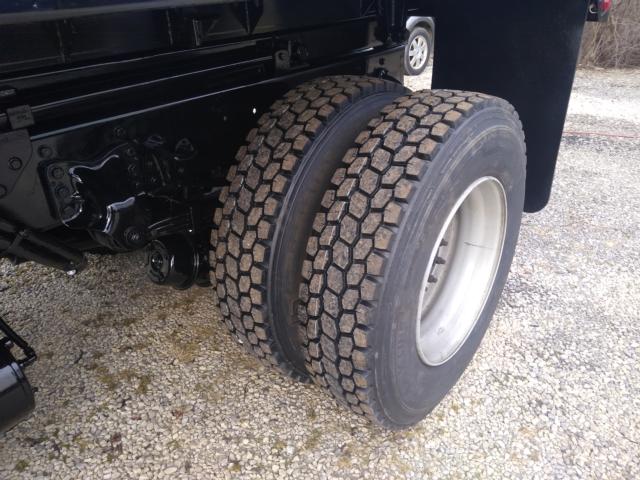 Freightliner M2 dual rear tires showing heavy-duty truck axle and wheel assembly.
