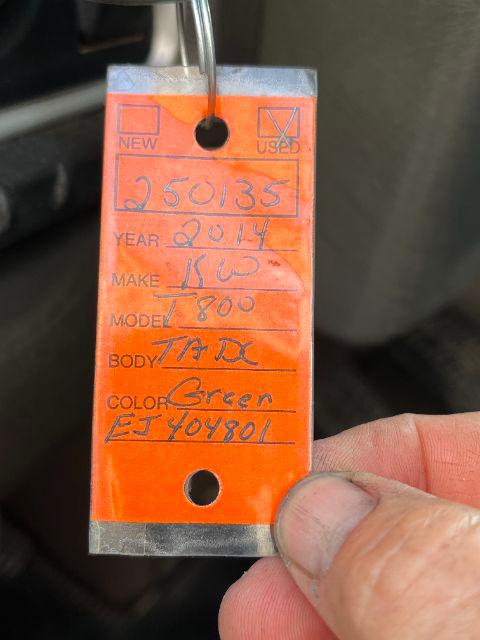 Tag on 2014 Kenworth T800 showing make and model details with handwritten entries: year 2014, make KW, model T800, body Day Cab (TD?); color Green; VIN/stock numbers not fully legible.