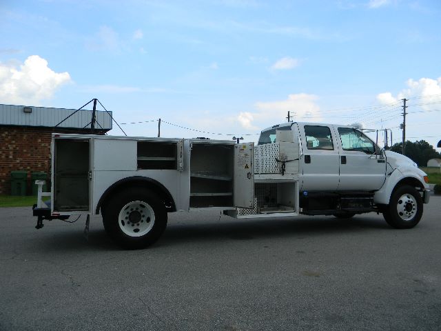 Service/Utility truck side profile with utility compartments, ladder rack, and crew cab. Ford F-750 badge not visible.