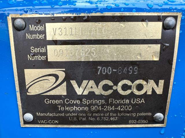 Plate on blue Vac-Con vehicle showing Model Number V311LIRAESG and Serial Number 09167825 with Vac-Con logo and contact info.