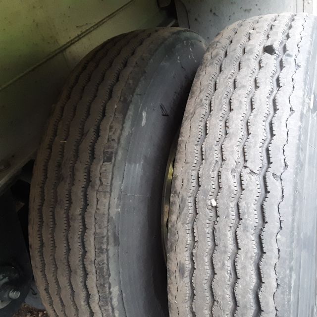 Trailer dual tires with ribbed tread on a Fontaine Revolution 52 flatbed trailer, side view of wheels.