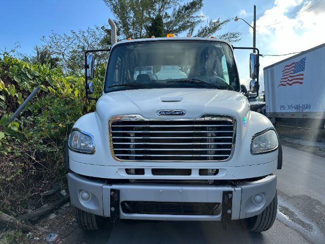 Front view of a white 2014 Freightliner M2 vacuum truck showing grille, headlights, bumper, and side mirrors.