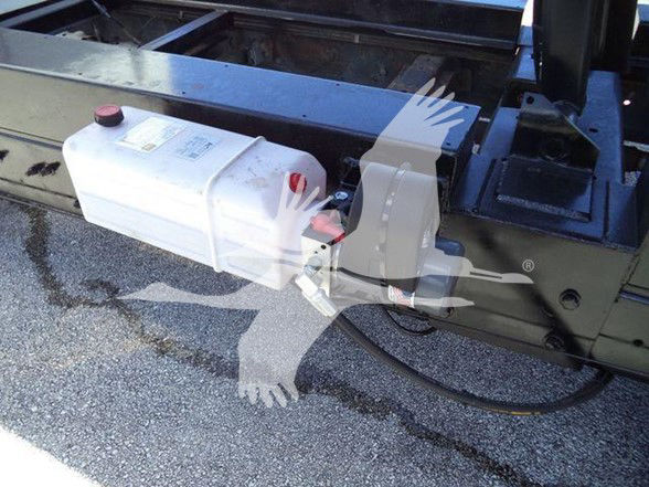 Ford E-450 dump truck with auxiliary tank and mounting at side rail.