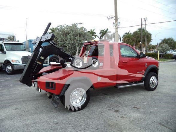 Red 2021 Ram 4500 SLT tow truck with a heavy-duty hydraulic bed in a parking lot.