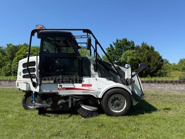 Elgin Pelican NP sweeper truck showing front-left view with side brush and debris containment.