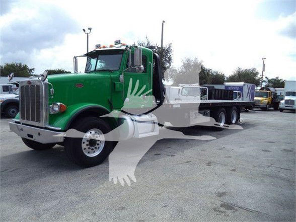 Peterbilt 367 truck with green cab and long chassis, tow truck configuration, front view.