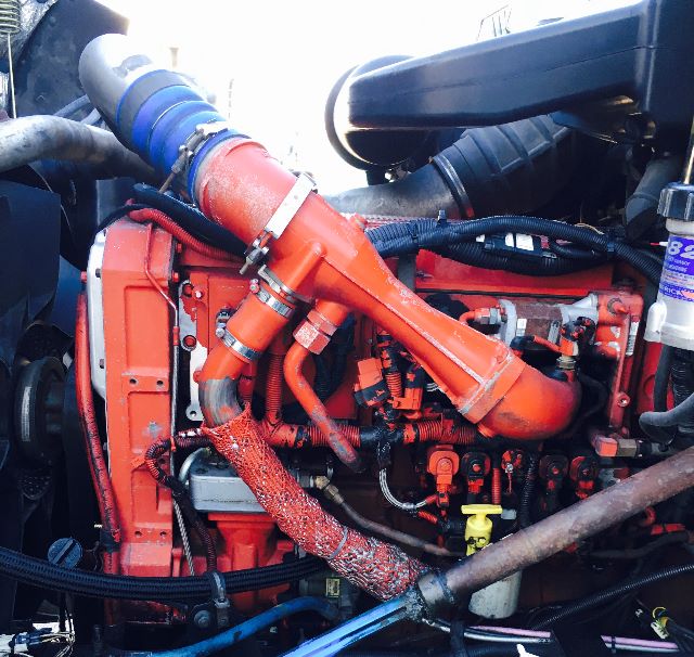 International diesel engine bay with bright orange intake plenum and related hoses and components.