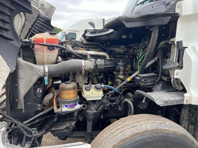 Front area of a 2017 Freightliner Cascadia engine bay showing coolant reservoir, hoses, and various engine components.