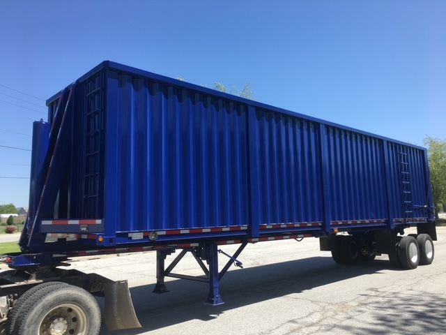 Blue 2006 utility 40 ft square dump trailer showing side panels and rear gate, mounted on dual axle with support legs.