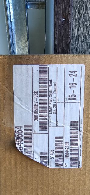 Label on cardboard box with barcodes and part numbers, upside down. Text includes numbers: 05-16-24? and 300-500? and 300-?; black printed barcode blocks and a small white sticker.