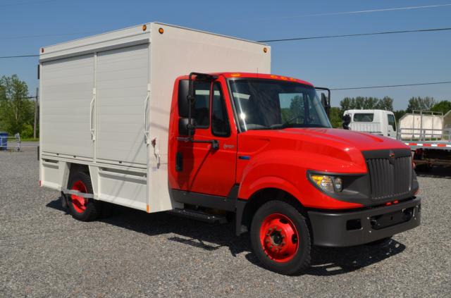 Isuzu/International TerraStar medium-duty box truck in red cab with white box, side view showing cargo area and front grille.